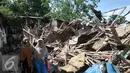 Warga Bukit Duri melintas di pinggir bangunan yang telah dirobohkan Satpol PP, Jakarta, Kamis (29/9). Pemprov DKI lanjutkan pembongkaran belasan rumah di Bukit Duri yang belum sempat dibongkar kemarin. (Liputan6.com/Yoppy Renato)