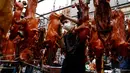 Seorang pedagang menyiapkan babi panggang untuk dijual di pasar menjelang Tahun Baru Imlek di Phnom Penh, Kamboja, Senin (31/1/2022). Tahun Baru Imlek mengawali Tahun Macan pada 1 Februari. (AFP/Tang Chhin Sothy)