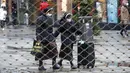 Dua biarawati terlihat berjalan dari balik pagar besi pusat perbelanjaan di Essen, Jerman, Senin (14/12/2020). Jerman melakukan lockdown nasional pada 16 Desember 2020 untuk memerangi pandemi COVID-19. (AP Photo/Martin Meissner)