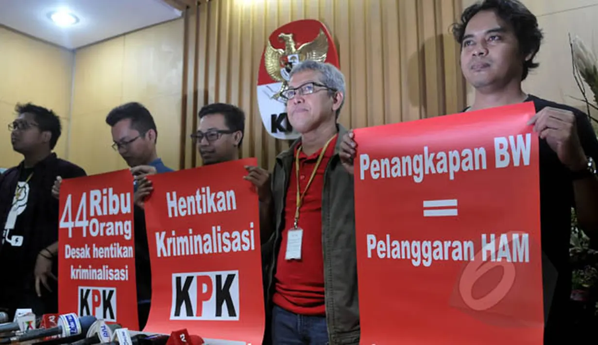 Pegiat anti korupsi yang tergabung dalam Koalisi Masyarakat Sipil Antikorupsi menunjukkan poster hentikan kriminalisasi KPK seusai melakukan konferensi pers menanggapi keputusan presiden di Gedung KPK, Jakarta, Kamis (19/2). (Liputan6.com/Johan Tallo)