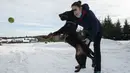 Lenka Vlachova, bermain salju dengan anjing Jagd Terrier miliknya bernama Laky di depan pusat pelatihan anjing pelacak COVID-19, Kliny, Republik Ceko, 22 Januari 2021. Studi ini dirancang untuk memverifikasi kemampuan anjing dalam mendeteksi COVID-19. (Michal Cizek/AFP)