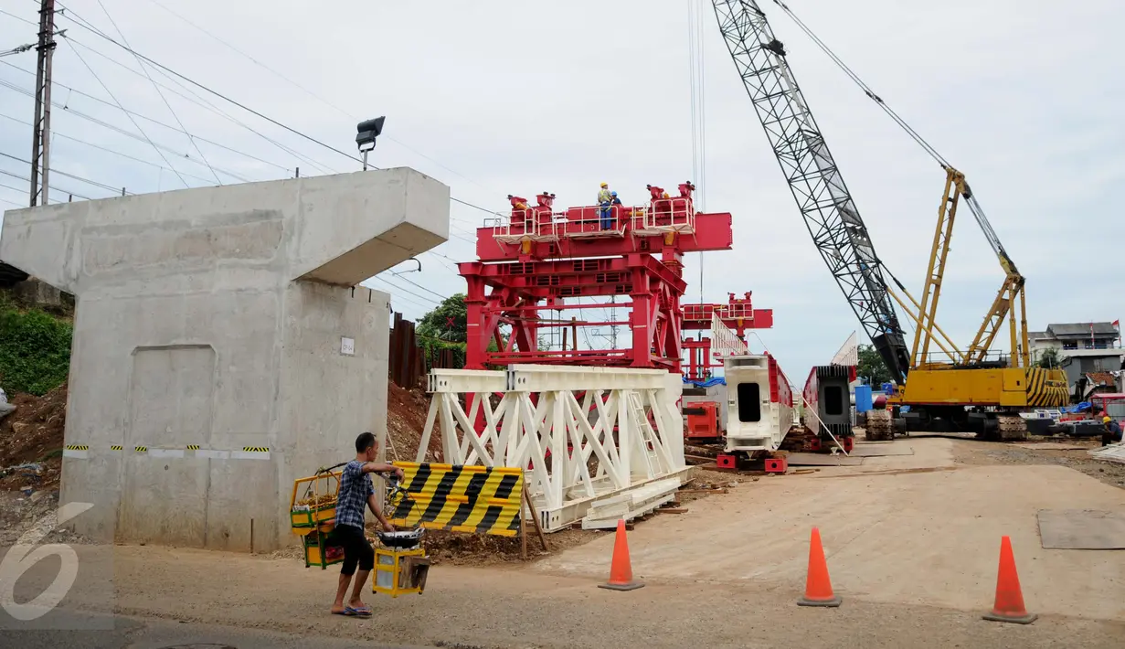 Pedagang melewati proyek pembangunan jalur dua rel ganda Manggarai-Cikarang, Jakarta, Jumat (13/1). Kemenhub akan bekerjasama dengan Pemda DKI untuk membantu mempercepat pembebasan lahan tersebut. (Liputan6.com/Gempur M Surya)