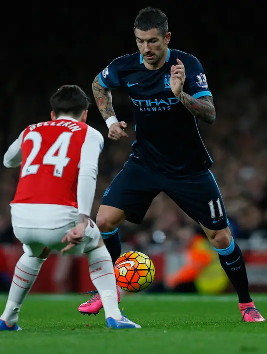 Bek Mancheseter City, Aleksandar Kolarov (kanan)  berusaha melewati bek Arsenal, Hector Bellerin pada lanjutan liga Inggris di Stadion Emirates (21/12). Arsenal menang atas City dengan skor 2-1. (AFP PHOTO/IKIMAGES)