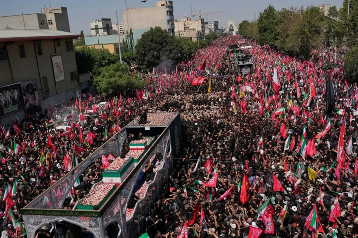 Truk yang membawa peti jenazah Pemimpin Tertinggi Iran Ayatollah Ali Khamenei dan anggota keluarganya melintasi kerumunan pelayat dalam prosesi pemakaman menuju Menara Azadi di Teheran, Iran, Senin, 6 Juli 2026.