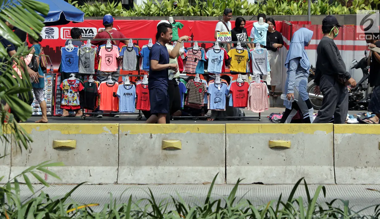 Pedagang kaki lima (PKL) menggelar dagangannya di Jalan Jenderal Sudirman saat Hari Bebas Kendaraan, Jakarta, Minggu (25/8/2019). Para PKL ini menggelar dagangannya terlalu menjorok ke tengah jalan sehingga mengganggu kenyamanan warga yang berolahraga saat CFD. (Liputan6.com/Helmi Fithriansyah)