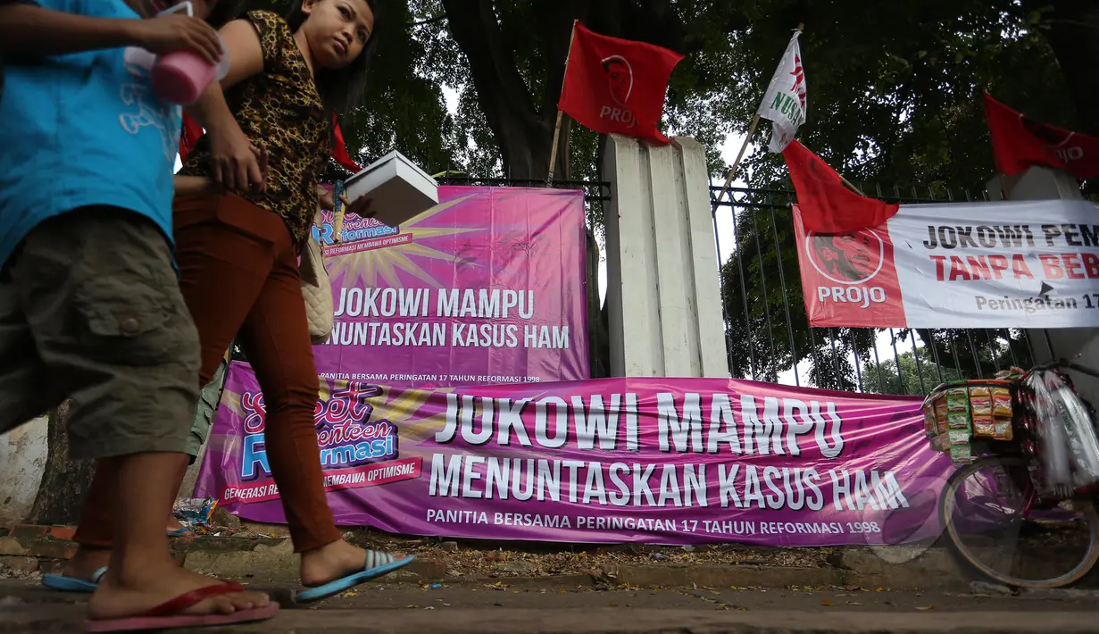Warga melintas di dekat spanduk yang bertuliskan dukungan untuk Jokowi di sekitar Tugu Proklamasi, Jakarta, Kamis (21/5/2015). Spanduk tersebut dipasang dalam rangka memperingati 17 tahun peringatan reformasi. (Liputan6.com/Faizal Fanani)
