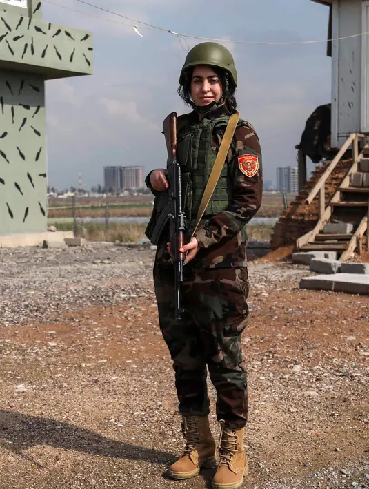 Seorang tentara wanita Peshmerga Kurdi, Arazo Qadri (27) berjaga di Kamp Militer Peshmerga di Arbil, ibu kota daerah otonomi Kurdi di Irak Utara, Selasa (20/2). (AFP PHOTO/SAFIN HAMED)