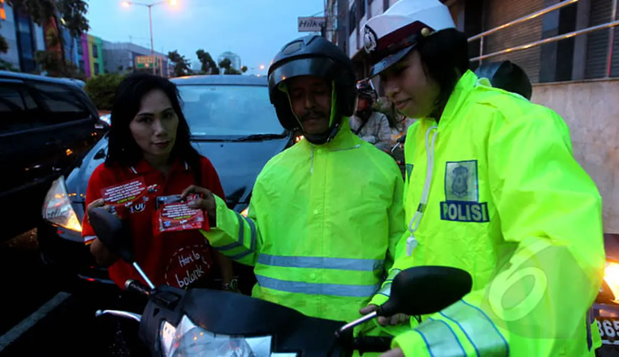 Kepolisian bekerjasama dengan Fullo mensosialisasikan larangan berhenti pada garis stop pada pengguna jalan diserta pembagian cokelat gratis pada pengendara yang tertib di kawasan Cideng, Jakarta, Senin (23/2). (Liputan6.com/Johan Tallo)
