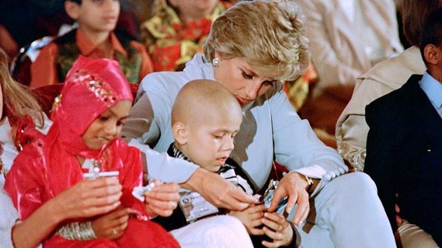 Princess of Wales memberi makan anak kecil yang terkena kanker selama acara amal di rumah sakit kanker pada 22 Februari 1996 di Lahore.