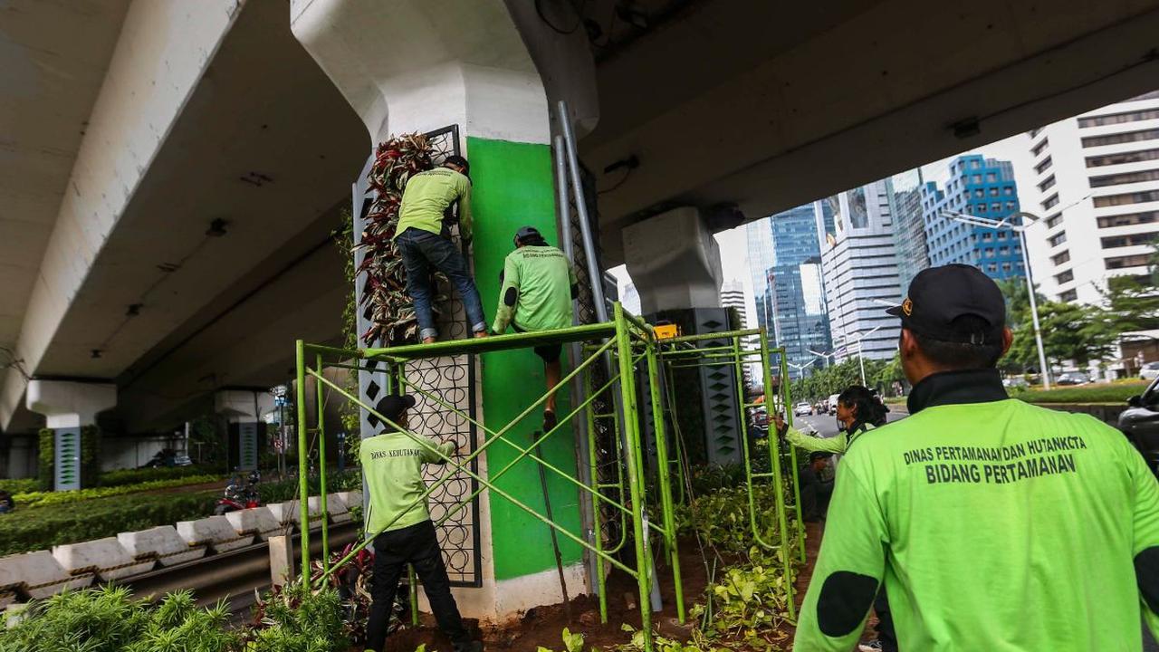 Pekerja dari Dinas Pertamanan dan Hutan Kota DKI Jakarta melakukan perbaikan pada rangka taman vertikal di Kawasan Jalan Jenderal Sudirman, Jakarta, Senin (11/3/2024). Foto: Liputan6.com / Angga Yuniar<br>
