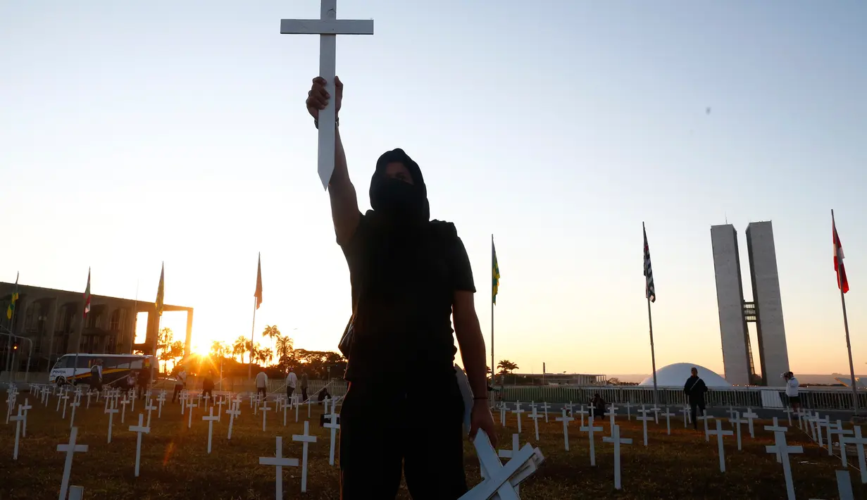 Sekitar 1.000 salib diletakkan di depan Kongres Nasional di Brasilia, Minggu (28/6/2020). Aksi tersebut merupakan protes terhadap Presiden Brasil Jair Bolsonaro dan untuk menghormati orang-orang yang meninggal karena COVID-19. (Sergio LIMA/AFP)