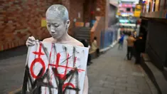 Seorang seniman tampil untuk memberikan penghormatan di sebuah gang di kawasan hiburan malam Itaewon yang populer di Seoul pada tanggal 29 Oktober 2024. (Shin Yong-ju/AFP)