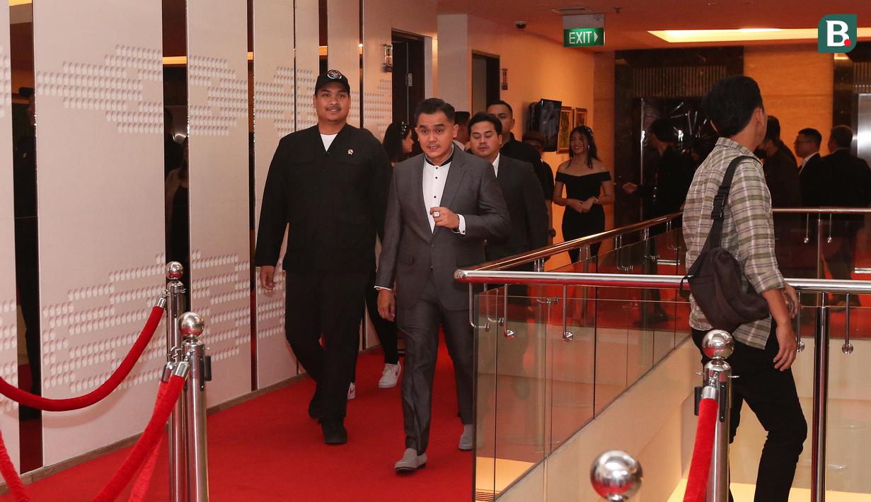 Menteri Pemuda dan Olahraga RI, Dito Ariotedjo berjalan di atas karpet merah pada sebuah acara yang berlangsung di Hotel JS Luwansa, Kuningan, Jakarta, Rabu (19/07/2023). Menpora Dito terlihat mengenakan pakaian dinas harian (PDH) berwarna hitam. (Bola.com/Bagaskara Lazuardi)