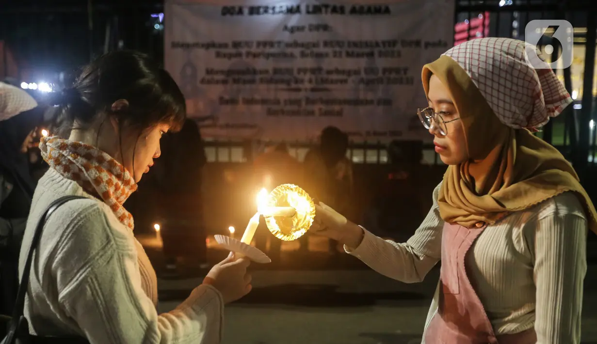 Massa menggelar aksi dengan membawa lilin dan doa bersama lintas agama di depan Gedung DPR, Jakarta, Kamis (16/3/2023). Dalam aksinya, mereka menuntut agar pimpinan DPR menetapkan RUU PPRT sebagai RUU INISIATIF DPR di Rapat Paripurna pada Selasa, 21 Maret 2023 mendatang. (Liputan6.com/Johan Tallo)