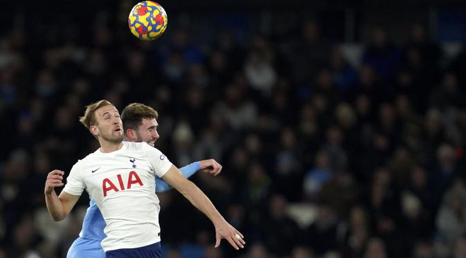 Penyerang Tottenham Hotspur Harry Kane melompat saat berebut bola dengan bek Manchester City Aymeric Laporte pada pekan ke-26 Liga Inggris di Etihad stadium, Minggu (20/2/2022) dinihari WIB. Manchester City takluk 2-3 dari tim tamu, Tottenham Hotspur.  (AP Photo/Jon Super)