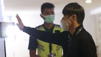 Pelatih Timnas Indonesia, Shin Tae-yong mengukur suhu tubuh saat tiba di Stadion Madya, Jakarta. (Foto: Bola.com/M. Iqbal Ichsan)