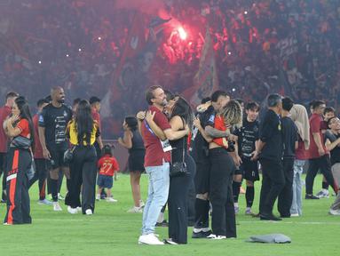 Pelatih Persija Jakarta, Mauricio Souza, memeluk istrinya saat merayakan kemenangan sekaligus ulang tahun ke-97 Persija di Stadion Utama Gelora Bung Karno (SUGBK), Senayan, Jakarta Pusat, Jumat (28/11/2025). (Bola.com/M Iqbal Ichsan)