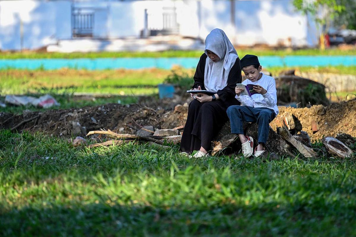 FOTO: Dua Puluh Satu Tahun Tsunami Aceh,  Warga Berziarah ke Kuburan Massal