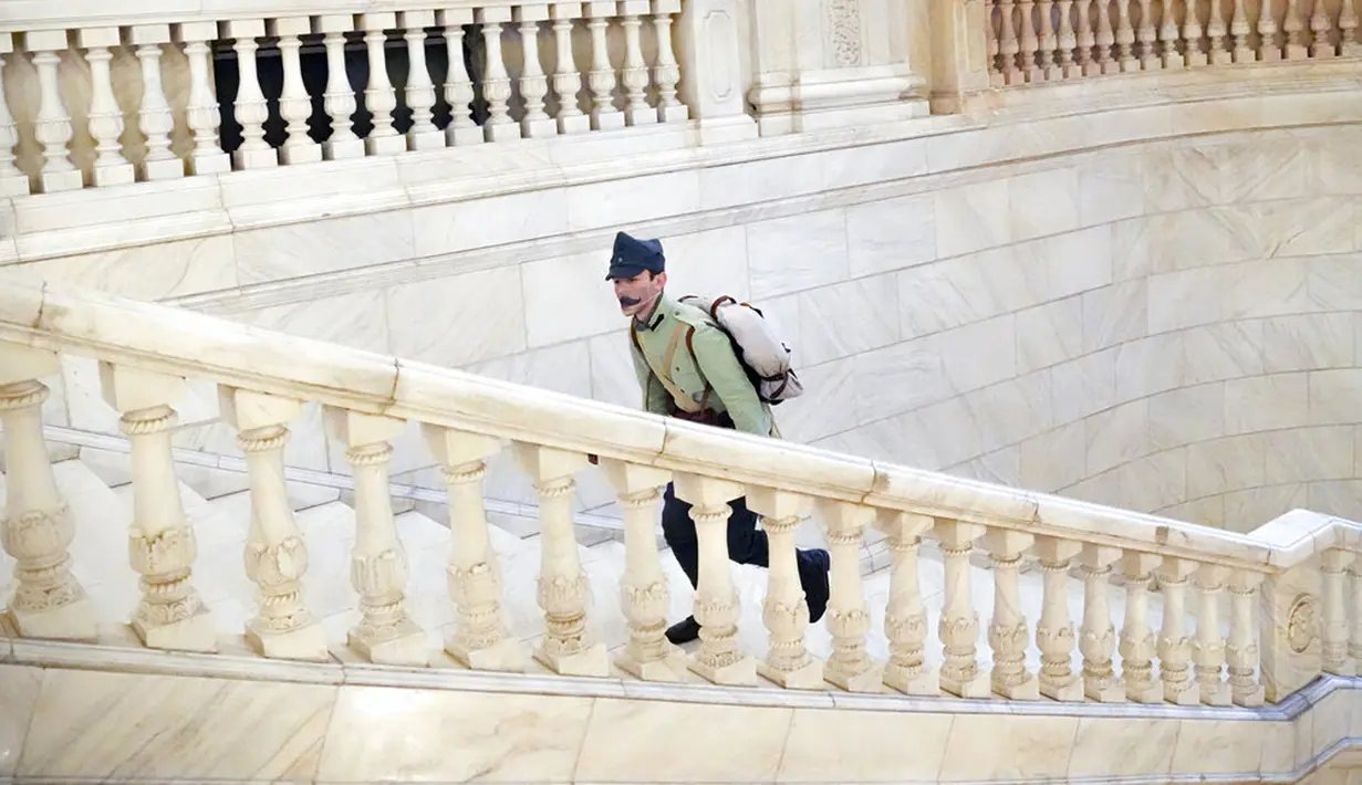 Seorang pria mengenakan seragam militer antik berjalan menaiki tangga Istana Parlemen pada Hari Anak Internasional di Bucharest, Rumania, Selasa (1/6/2021). Lebih dari 10 ribu anak-anak dan orang dewasa mengunjungi gedung era komunis yang juga dikenal House of the People. (AP Photo/Vadim Ghirda)