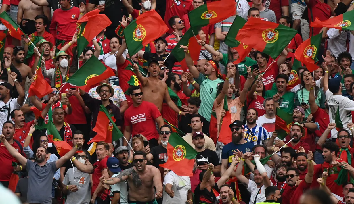 Fans timnas Portugal merayakan gol yang dicetak Raphael Guerreiro pada laga Grup F EURO 2020 kontra Hungaria di Puskas Arena, Selasa (15/6/2021). Pertandingan yang dimenangkan oleh Portugal 3-0 itu dihadiri lebih dari 60.000 penonton atau kapasitas maksimal Stadion. (Attila KISBENEDEK/ POOL /AFP)