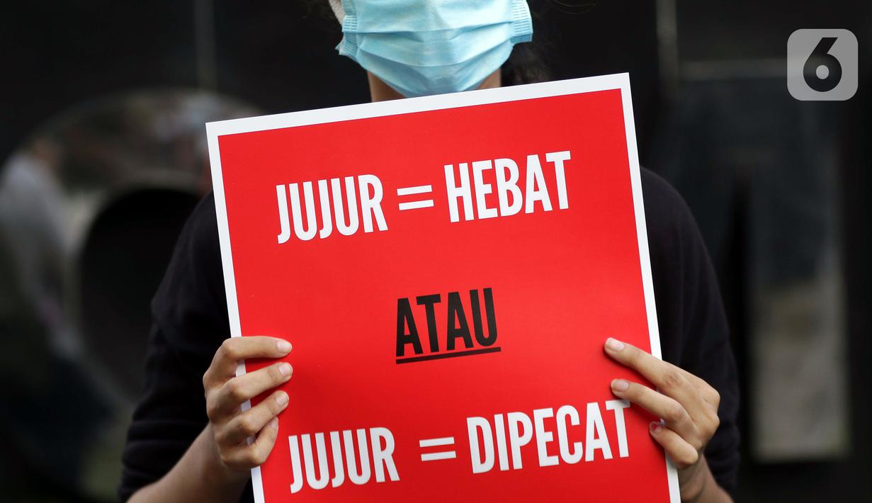 Peserta aksi dari Koalisi Masyarakat Sipil AntiKorupsi membawa poster saat berunjukrasa di depan Gedung KPK Jakarta, Selasa (18/5/2021). Dalam aksinya mereka memberi dukungan kepada 75 pegawai KPK yang dinyatakan tidak lulus TWK dalam tahap alih status kepegawaian. (Liputan6.com/Helmi Fithriansyah)