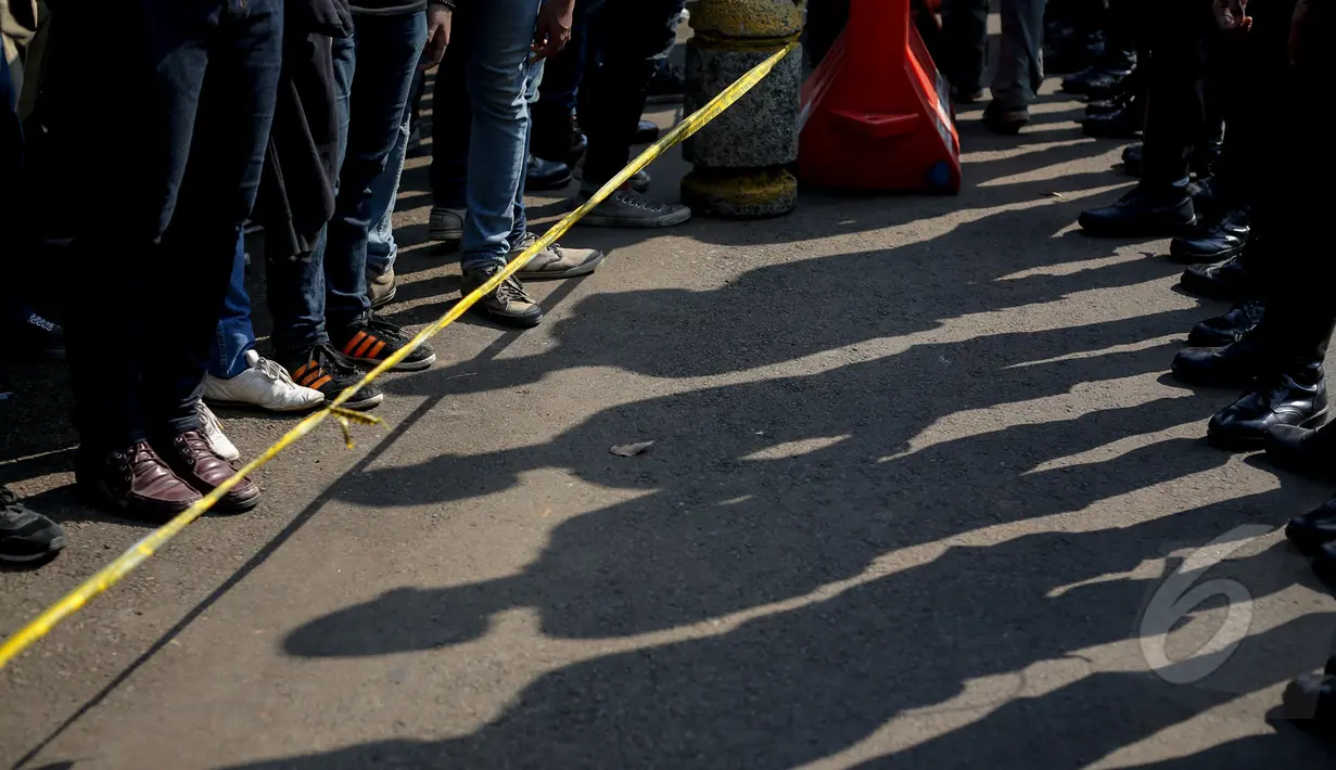Aksi mahasiswa dibatasi oleh garis pembatas saat demo ‘Menolak Lupa’ di depan Istana Merdeka, Jakarta, Selasa (12/5/2015). Mereka menuntut pemerintah untuk mengusut Tragedi 12 Mei 1998 yang menewaskan 4 mahasiswa Trisakti. (Liputan6.com/Faizal Fanani)