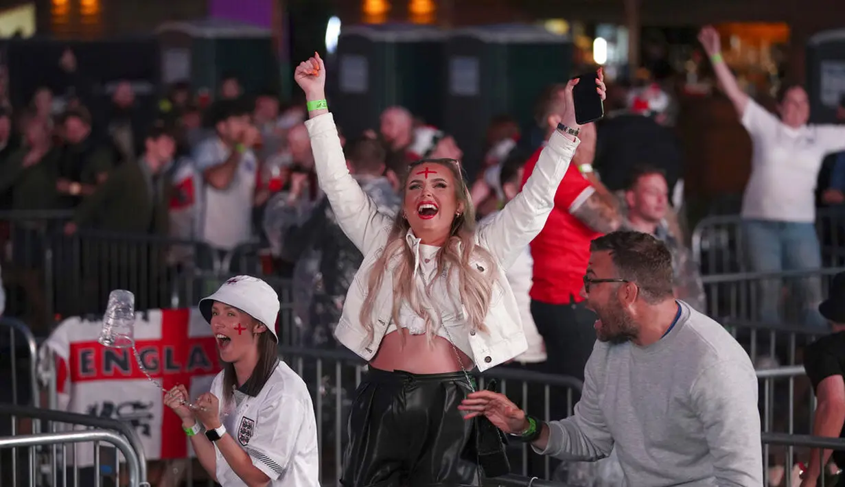 Fans di Manchester merayakan gol kedua Inggris, yang dicetak oleh Harry Kane, saat mereka menonton di layar lebar pertandingan semifinal kejuaraan Euro 2020 antara Inggris dan Denmark, di Manchester, Inggris  (8/7/2021). (Martin Rickett/PA via AP)