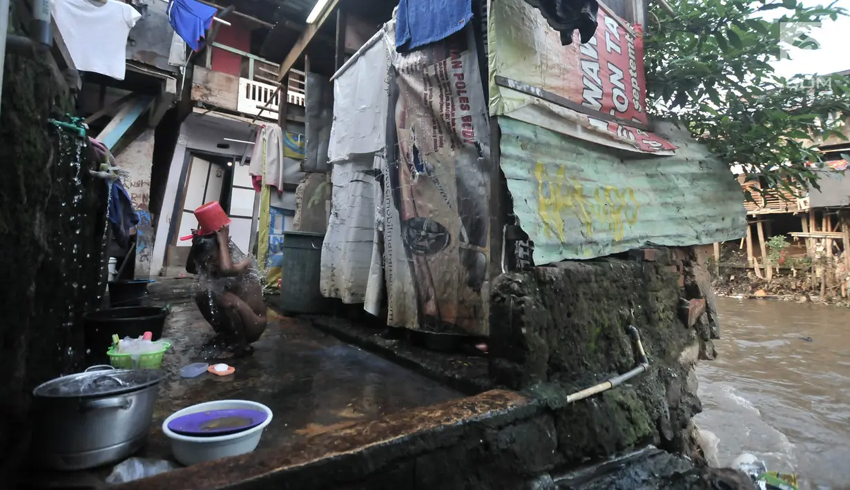 Seorang anak mandi di toilet umum kawasan bantaran Kali Ciliwung, Jakarta, Senin (19/11). Saat ini, tercatat sekitar 500 ribu penduduk DKI Jakarta tidak memiliki akses sanitasi yang layak. (Merdeka.com/Iqbal Nugroho)