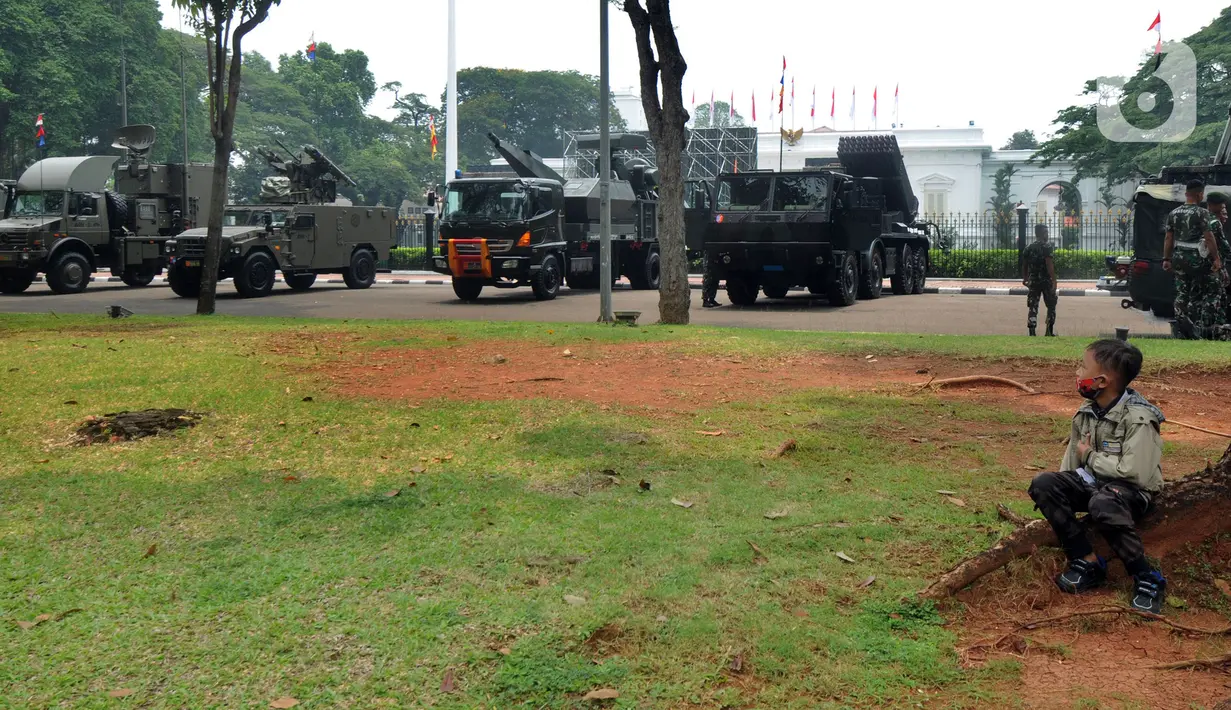 Seorang anak duduk dekat kendaraan taktis TNI yang dipamerkan di depan Istana Merdeka, Jakarta, Senin (4/10/2021). Ratusan alat utama sistem persenjataan (Alutsista) TNI dipamerkan sepanjang pinggir jalan sekeliling kawasan Monas dalam rangka peringatan HUT ke-76 TNI. ​(merdeka.com/Arie Basuki)