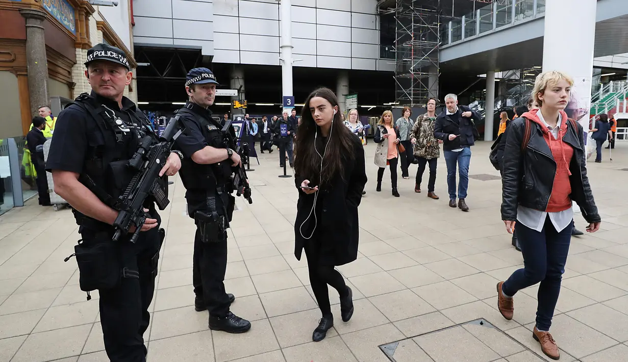 Polisi bersenjata berpatroli di area pintu masuk menuju Manchester Arena dekat stasiun kereta Manchester Victoria, Inggris, (30/5). Stasiun itu kembali dibuka setelah lebih dari sepekan insiden pengeboman di Manchester Arena. (Owen Humphreys/PA via AP)