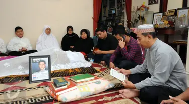 Pelayat membaca Al Quran disisi jenazah Ketua KPU, Husni Kamil Manik di kompleks KPU, Jakarta, Jumat (8/7). Husni Kamil Manik wafat pada Kamis (7/7) di usia 40 tahun. (Liputan6.com/Helmi Fithriansyah)