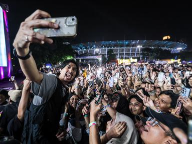 Vokalis Sheila on 7, Akhdiyat Duta Modjo melakukan swafoto bersama para penonton Kapanlagi Buka Bareng (KLBB) 2026 yang berlangsung di Stadion Madya, Senayan, Jakarta, Minggu (01/03/2026). (Bola.com/Bagaskara Lazuardi)