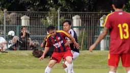 Pemain depan Paski-Man FC, Beddu (tengah) berebut bola dengan Augie Fantinus (Selebriti FC) saat berlaga di turnamen Agum Gumelar Cup di Lapangan C Senayan, Jakarta (9/1/2015). Paski-Man FC unggul 1-0 atas Selebrity FC. (Liputan6.com/Helmi Fithriansyah)