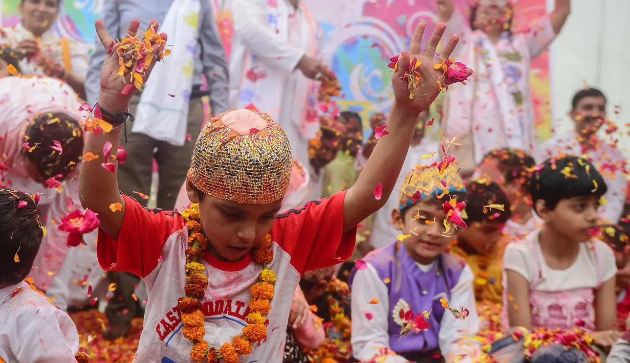 Anak-anak India bermain dengan kelopak bunga di sebuah acara untuk merayakan festival Hindu Holi untuk anak-anak cerebral palsy yang diselenggarakan oleh Yayasan Trishla di Allahabad (25/2). (AFP Photo/Sanjay Kanojia)