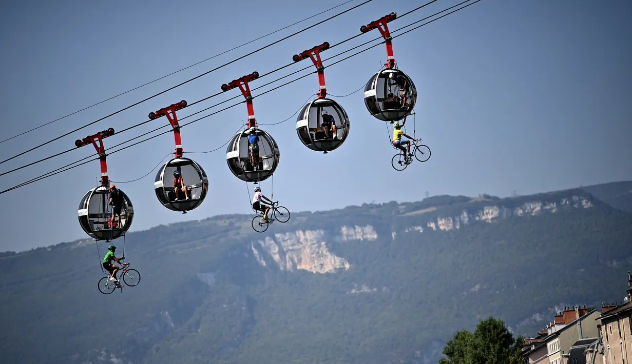 Sejumlah pembalap sepeda tergantung di bawah kereta gantung Grenoble Bastille pada ajang Tour de France di Grenoble, Rabu (16/9/2020). (AFP/Anne-Christine Poujoulat)