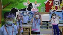 Siswa dengan masker dan pelindung wajah mengikuti hari pertama kelas tatap muka di sekolah dasar Comembo di kota Makati, Filipina, Senin (6/12/2021). Beberapa sekolah di Manila diizinkan dibuka kembali setelah berbulan-bulan lamanya karena kasus COVID-19 terus menurun. (AP Photo/Aaron Favila)