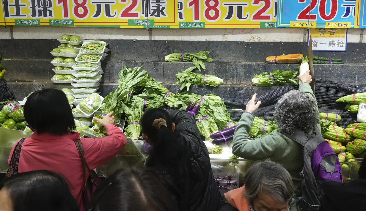 Pelanggan mengenakan masker, membeli sayuran segar di toko pasar basah di Hong Kong, Rabu, 9 Februari 2022. Hong Kong mengumumkan pembatasan virus corona baru yang ketat yang diperparah dengan semakin minimnya pasokan sayuran dikarenakan pengemudi truk yang positif COVID-19. (AP Photo/Vincent Yu)