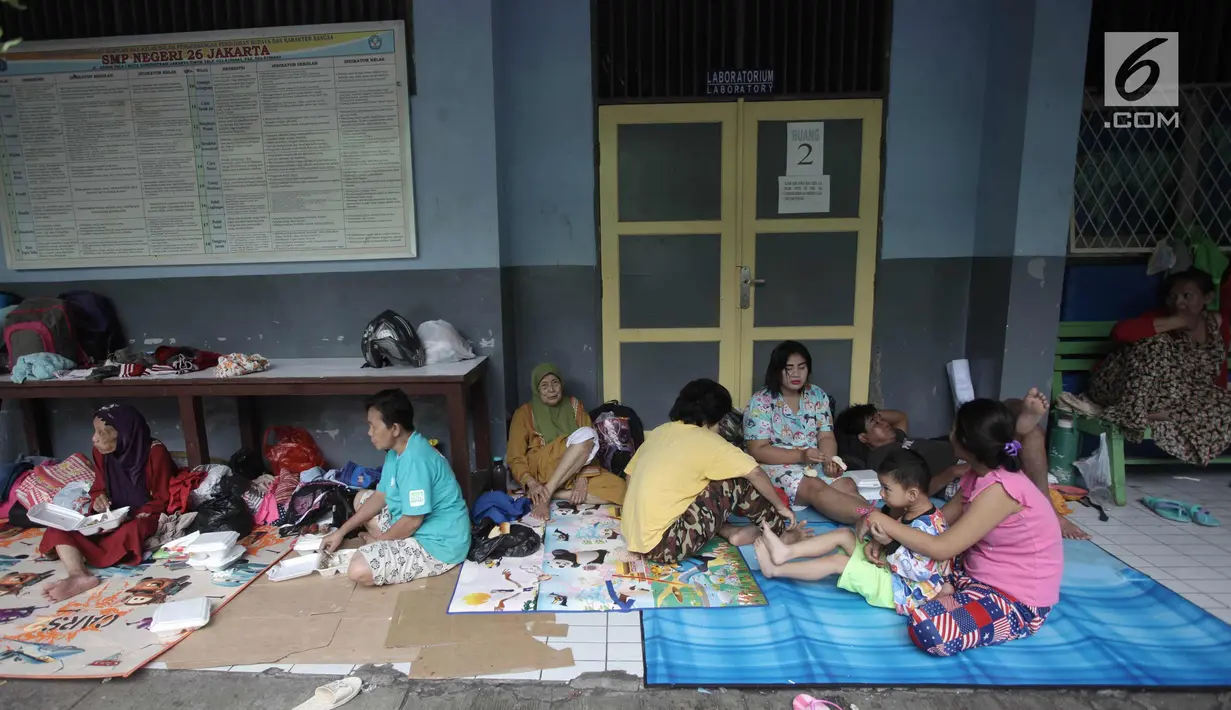 Warga beristirahat di Gedung SMP Negeri 26, Jalan Kebon Pala, Kampung Melayu, Jatinegara, Jakarta Timur, Selasa (6/2). Sebanyak 42 KK mengungsi di tempat tersebut akibat rumahnya terendam banjir. (Liputan6.com/Arya Manggala)