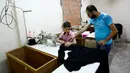  Bocah pengungsi Suriah saat mendengarkan instruksi dari ayahnya yang juga bekerja di pabrik tekstil, Istanbul, Turki, (24/6). Mereka bekerja untuk membantu orang tuanya untuk hidup selama mengungsi di Turki. (REUTERS/Umit Bektas)