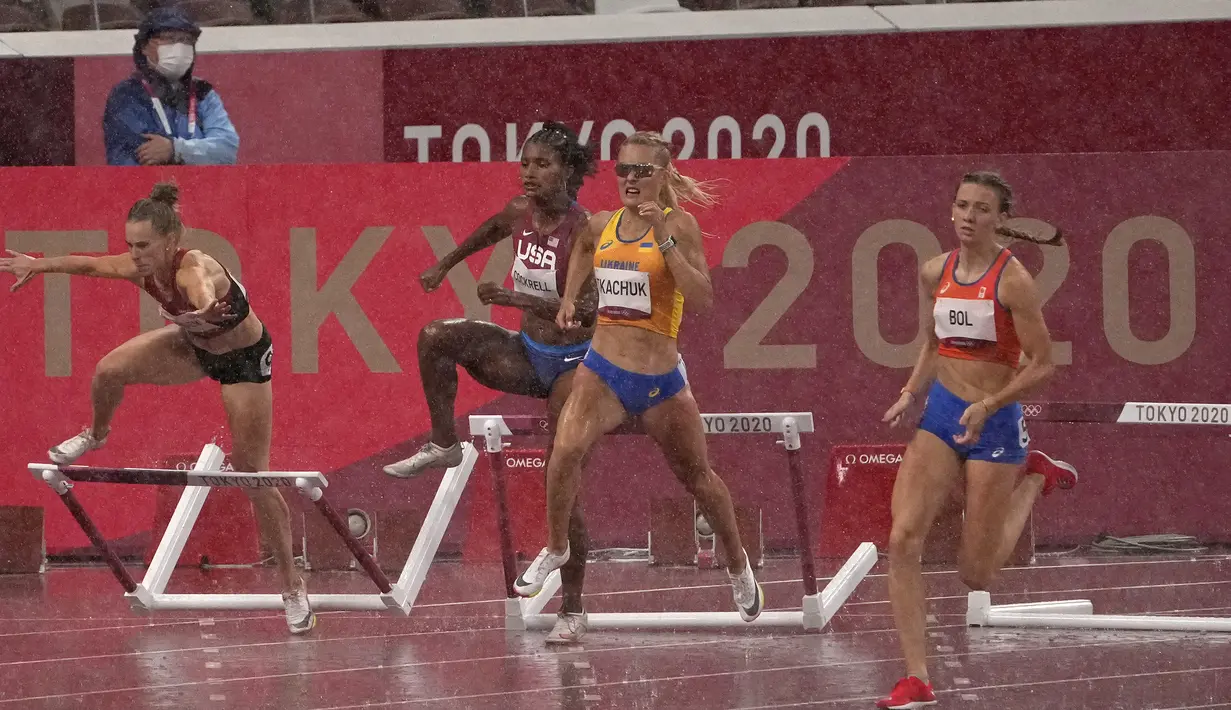Sara Petersen (kiri) dari Denmark terjatuh saat Femke Bol (kanan) , dari Belanda berlomba untuk memenangkan perlombaan lari gawang 400 meter putri Olimpiade Tokyo 2020 di Tokyo, Jepang, Senin (2/8/2021). (AP Photo/Charlie Riedel)