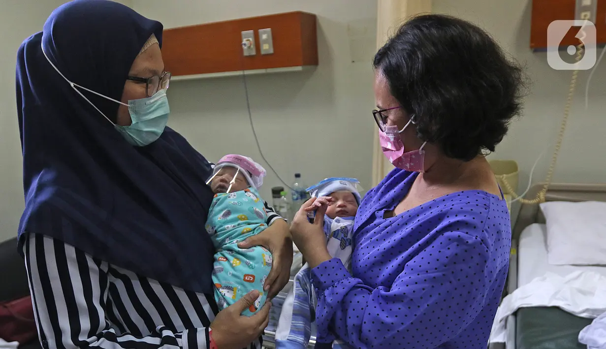 Dua bayi memakai face shield atau pelindung wajah di Rumah Sakit Ibu dan Anak Tambak, Jakarta, Selasa (14/4/2020). RSIA Tambak sejak 12 April 2020 membuat kebijakan bayi yang baru lahir dipakaikan pelindung wajah untuk mencegah terpapar virus corona COVID-19. (Liputan6.com/Herman Zakharia)