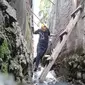 Ngadenin (63), warga Jalan Raya Jatiwaringin RT 03 RW 04 Jati Cempaka, Pondok Gede, Kota Bekasi, terpaksa harus melewati saluran got untuk menuju rumahnya, karena akses jalan tertutup tembok hotel. (Istimewa)