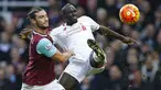 Bek Liverpool, Mamadou Sakho, berebut bola dengan striker West Ham, Andy Carroll, pada laga Liga Premier Inggris di Stadion Boleyn Ground, Inggris, Sabtu (2/1/2016). Liverpool takluk 0-2 dari West Ham. (Reuters/John Sibley)