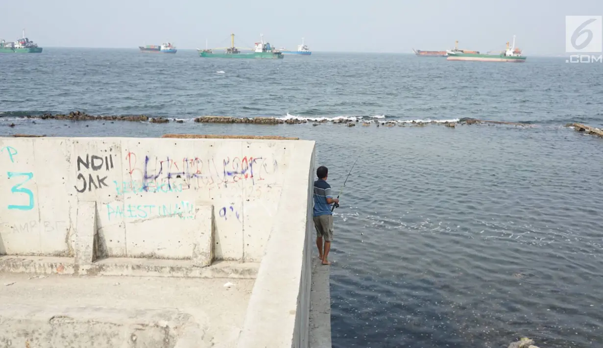 Warga memancing di perbatasan laut dan daratan di kawasan Muara Baru, Jakarta Utara, Selasa (30/7/2019). Naiknya permukaan air laut selama bertahun-tahun menyebabkan kawasan tersebut terendam banjir hingga menyatu dengan lautan. (Liputan6.com/Immanuel Antonius)