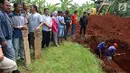 Warga menggali makam untuk korban kecelakaan Tanjakan Emen di Tempat Pemakaman Umum (TPU) Legoso, Tangerang Selatan, Banten, Minggu (11/2). Sebanyak 26 korban tewas merupakan warga Tangerang Selatan. (Liputan6.com/JohanTallo)