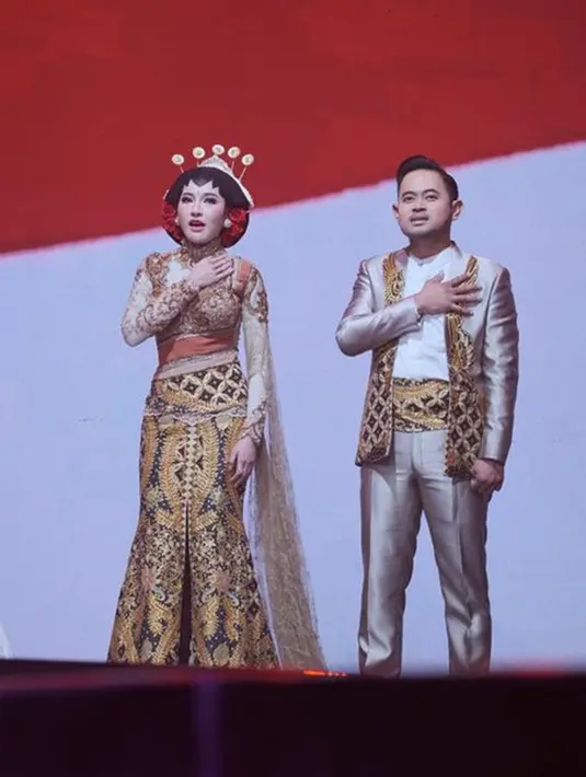 Begini penampilan Gilang Widya Pramana dan Shandy Purnamasari saat memakai baju adat berwarna kuning keemasan. Gayanya banjir pujian dari warganet. (Liputan6.com/IG/@juragan_99)
