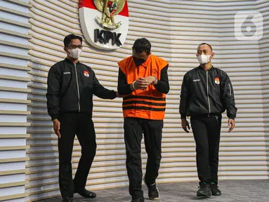 Bupati Sidoarjo Ahmad Muhdlor Ali (tengah) mengenakan rompi orange usai mengikuti konferensi pers penahanannya sebagai tersangka di Gedung Merah Putih Komisi Pemberantasan Korupsi (KPK), Jakarta, Selasa (7/5/2024). (Liputan6.com/Angga Yuniar)