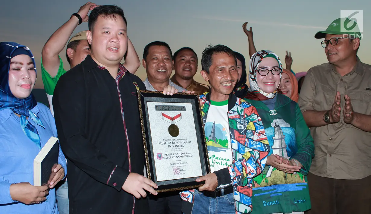 Museum Rekor Muri memberikan penghargaan sate terbanyak dalam Festival Pesona Danau Limboto, Gorontalo, Senin (24/9). MURI mencatat sebanyak 88.950 tusuk sate berhasil memecahkan rekor dunia untuk sajian sate terbanyak. (Liputan6.com/Arfandi Ibrahim)