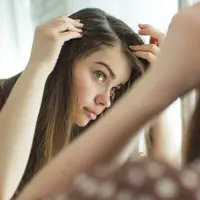 Ilustrasi perempuan sedang melihat kerontokan rambutnya. (Foto: Shutterstock)