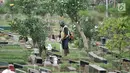 Petugas kebersihan memotong rumput makam di TPU Karet Bivak, Jakarta, Kamis (12/7). Data Dinas Kehutanan DKI mencatat dari 611,59 hektare lahan makam yang sudah dibebaskan, 60 persen atau 365,13 hektare sudah dipakai. (Merdeka.com/Iqbal Nugroho)